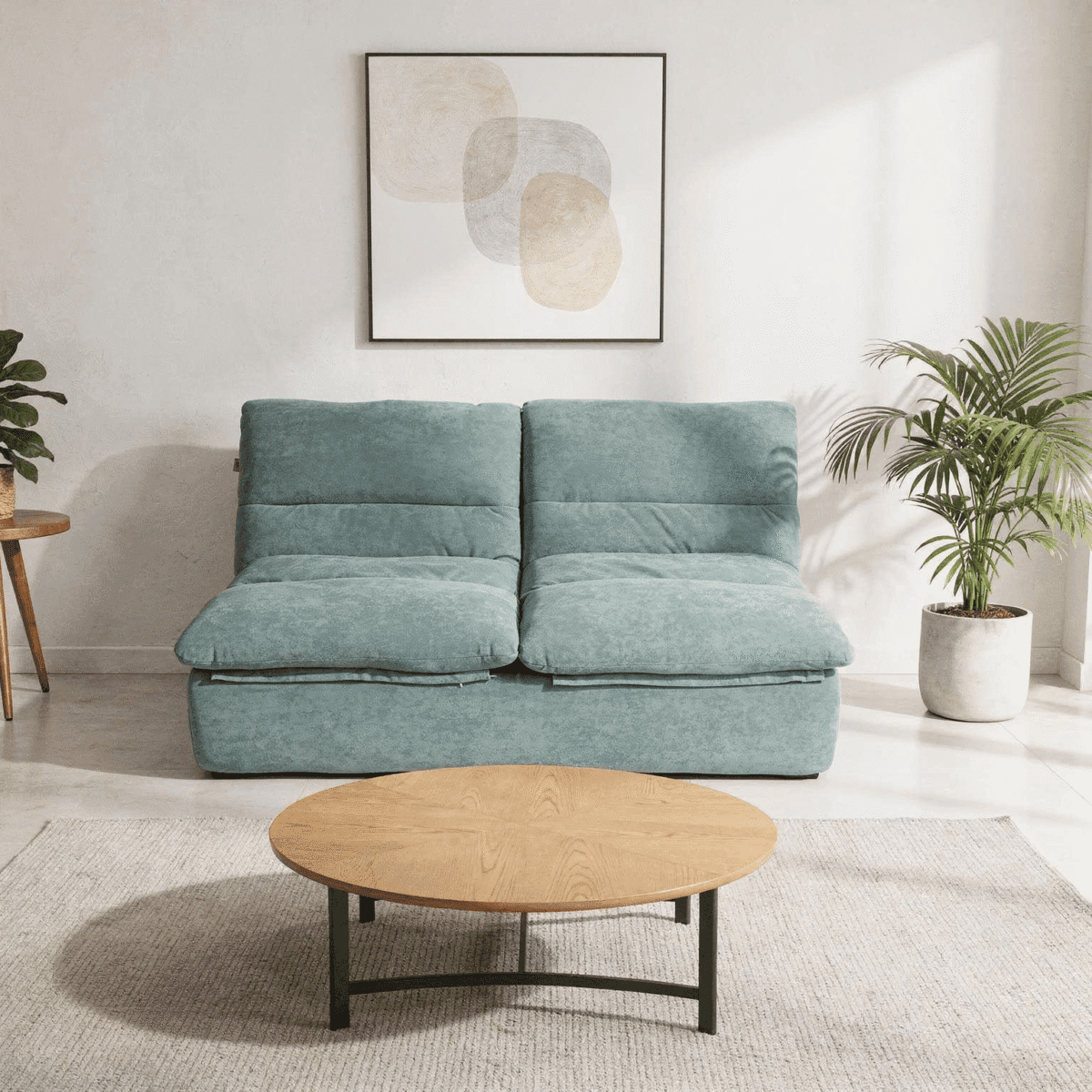 Canapé 2 places bleu vert dans salon moderne lumineux avec table basse ronde et plantes
