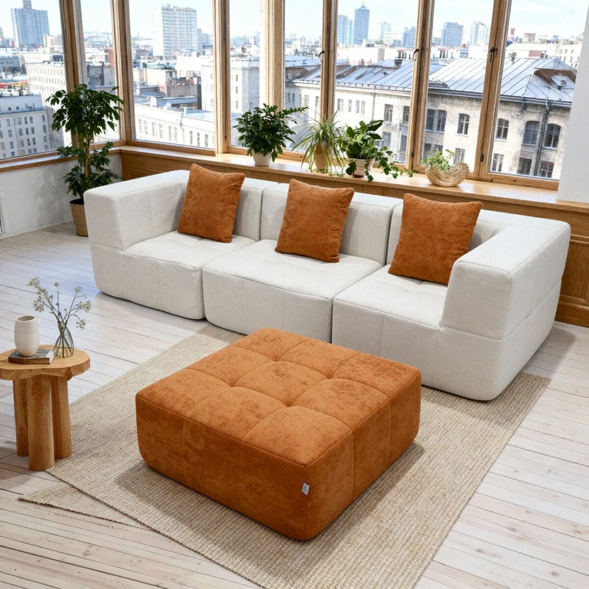Salon moderne lumineux avec canapé blanc, coussins orange, ottoman assorti, grandes fenêtres et plantes