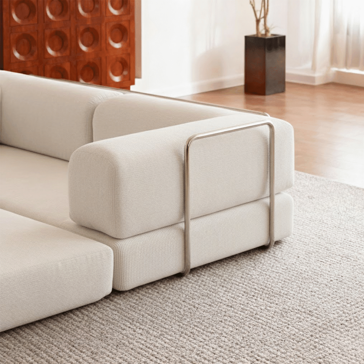 Canapé d’angle moderne beige dans salon minimaliste avec parquet bois, grande baie vitrée et déco élégante