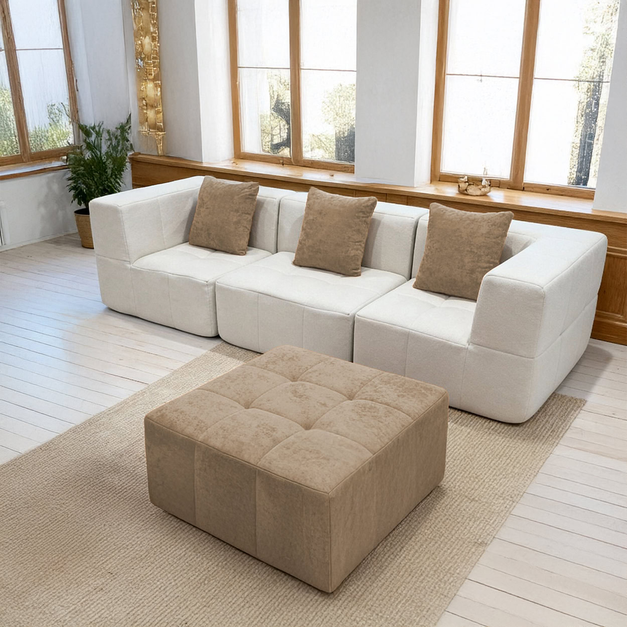 Salon moderne lumineux avec canapé modulable blanc, ottoman beige et grande baie vitrée sur jardin