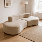 Canapé beige arrondi design contemporain dans salon lumineux avec parquet bois, tapis texturé et lampe moderne