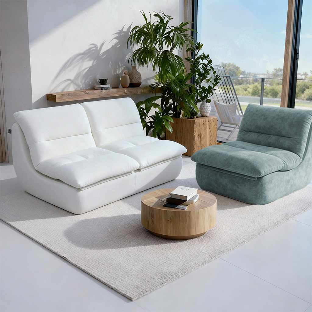 Salon moderne lumineux avec canapé blanc, fauteuil vert d’eau, table basse ronde et plante verte