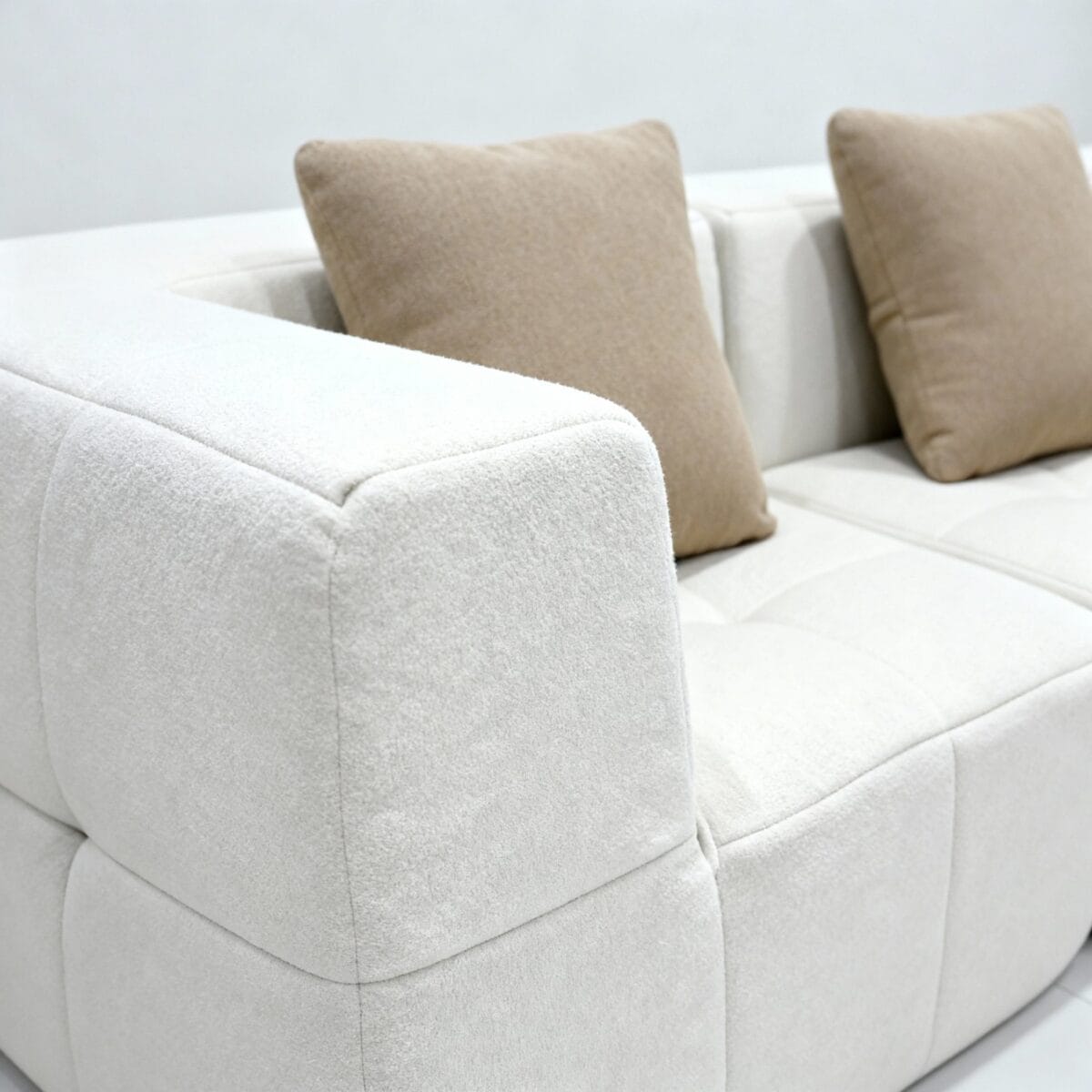 Canapé moderne minimaliste en tissu beige clair avec coussins assortis dans salon contemporain élégant