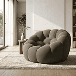 Sofa cocon en tissu gris foncé dans un intérieur lumineux et épuré.