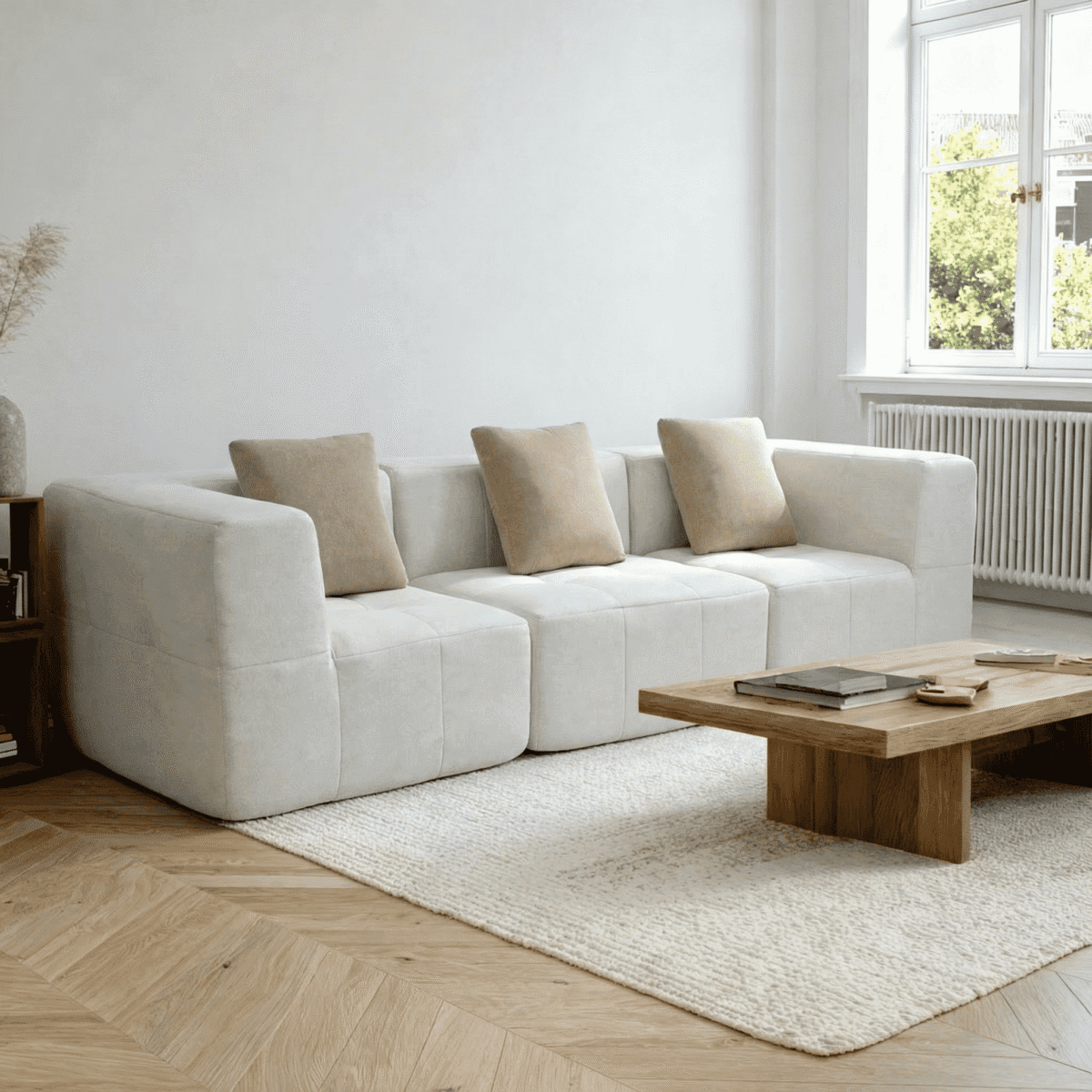 Salon minimaliste lumineux avec canapé d’angle blanc, table basse en bois et grande fenêtre verdoyante