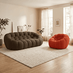 Canapé modulable en tissu gris foncé avec fauteuil orange dans un salon lumineux. Canapé modulable gris foncé et fauteuil orange dans un salon lumineux.